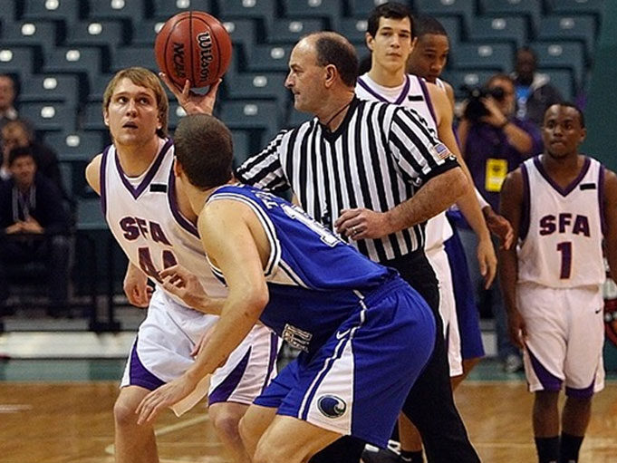 a basketball official throws the ball upward